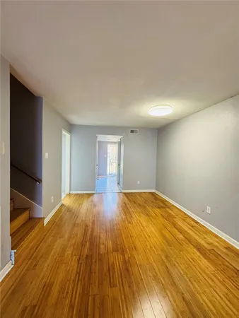 a view of empty room with wooden floor