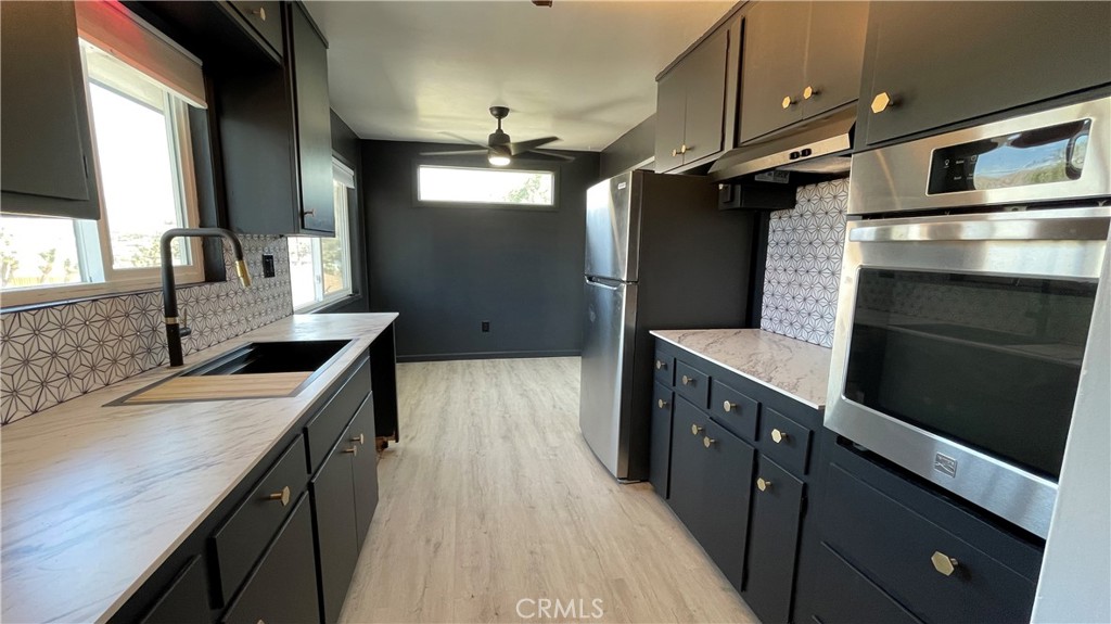 7428 Acoma Trail Yucca Valley, CA 92284 - Photo 12 of 18 a kitchen with stainless steel appliances granite countertop a sink stove and refrigerator