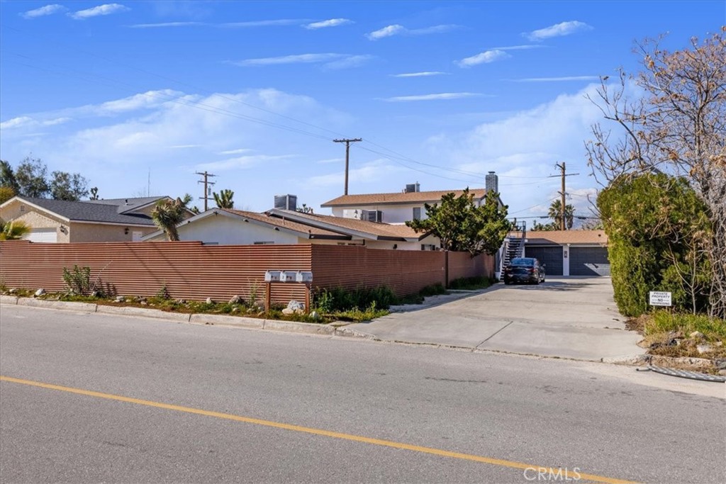 7428 Acoma Trail Yucca Valley, CA 92284 - Photo 2 of 18 a front view of a house with a yard and garage