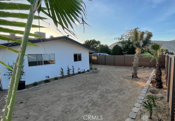 7428 Acoma Trail Yucca Valley, CA 92284 - Photo 8 of 18 a backyard of a house with lots of green space and glass windows
