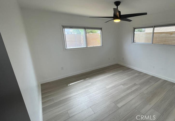 7428 Acoma Trail Yucca Valley, CA 92284 - Photo 10 of 18 an empty room with wooden floor fan and windows