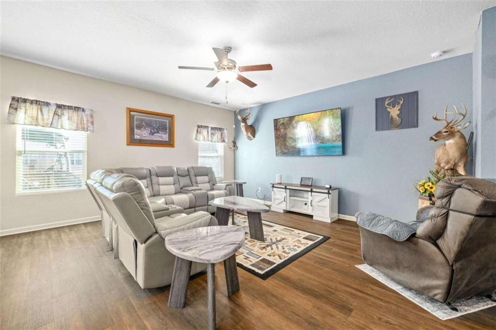 306 Seasons Valley Pendergrass, GA 30567 - Photo 8 of 37 a living room with furniture a chandelier and a flat screen tv
