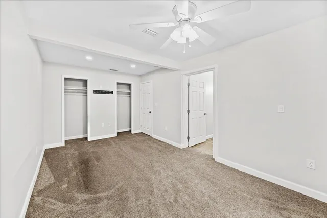 an empty room with a ceiling fan and a window