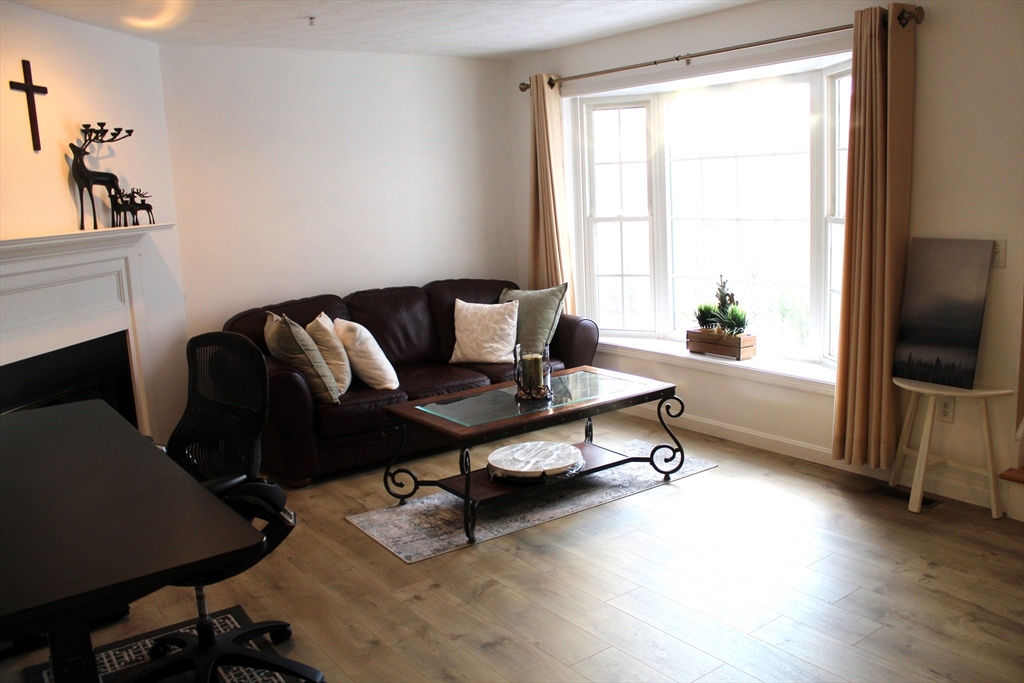 38 Georgetown Drive, Unit 38 Nashua, NH 03062 - Photo 11 of 26 a living room with furniture and a flat screen tv