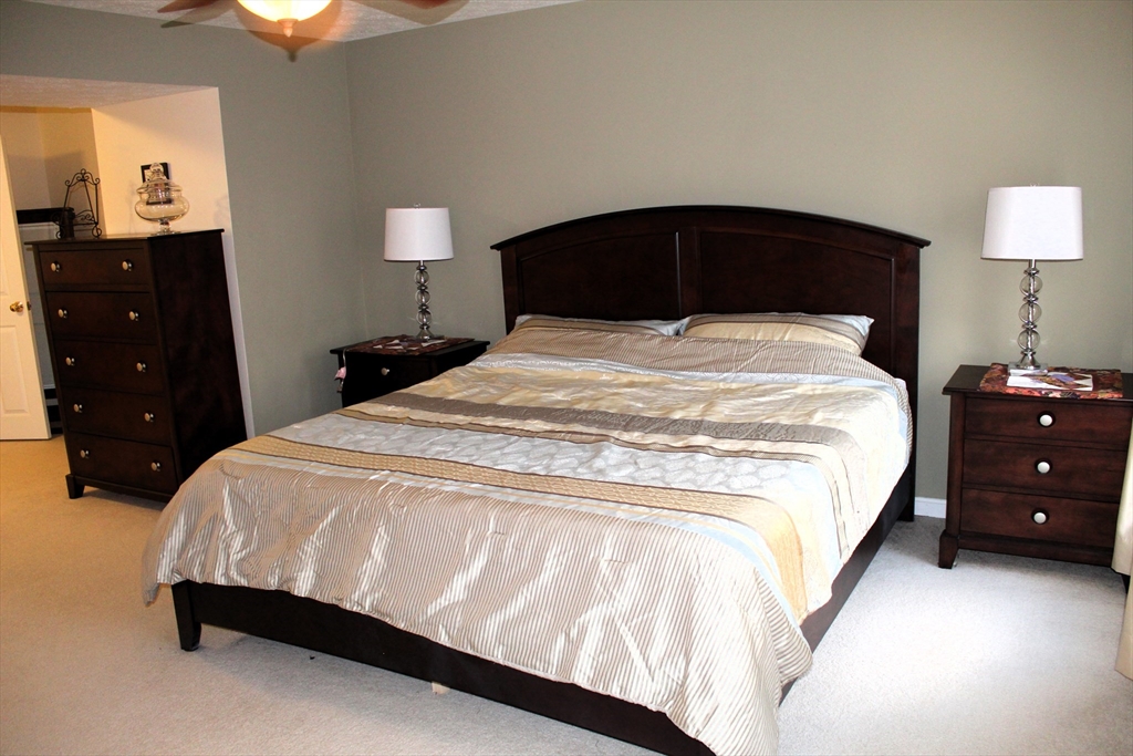 38 Georgetown Drive, Unit 38 Nashua, NH 03062 - Photo 15 of 26 a bedroom with a bed and a lamp