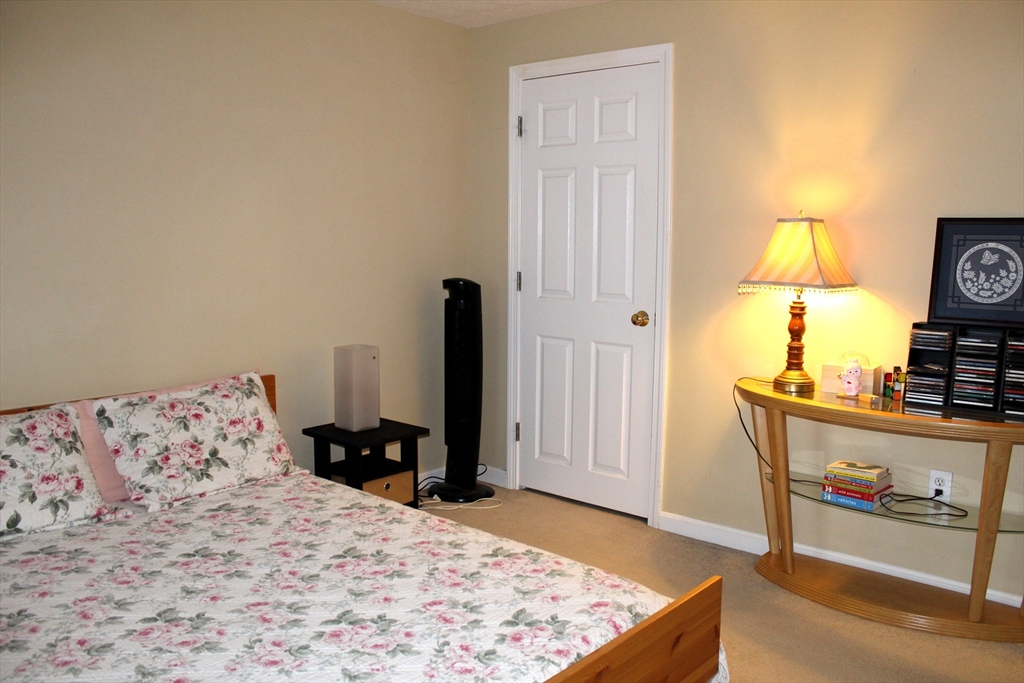 38 Georgetown Drive, Unit 38 Nashua, NH 03062 - Photo 22 of 26 a bedroom with a bed and wooden floor
