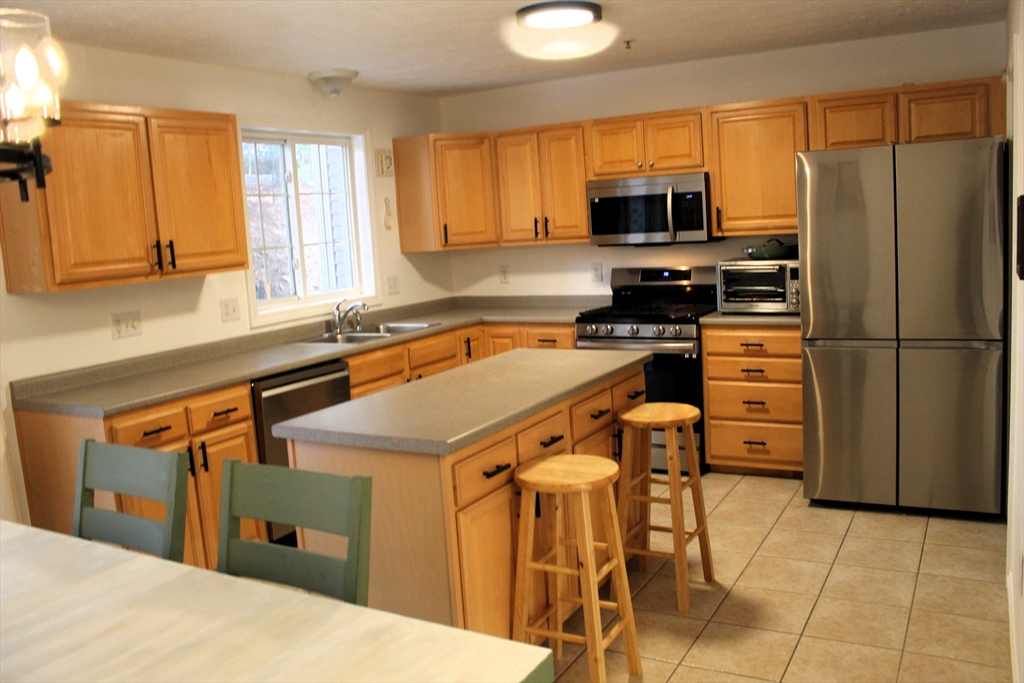 38 Georgetown Drive, Unit 38 Nashua, NH 03062 - Photo 4 of 26 a kitchen with a sink a microwave and refrigerator