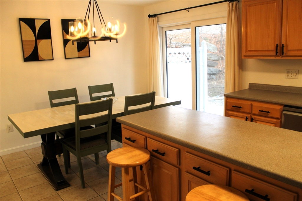 38 Georgetown Drive, Unit 38 Nashua, NH 03062 - Photo 8 of 26 a view of a kitchen with a table and chairs