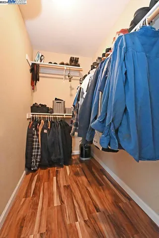 a living room with furniture a large window and wooden floor