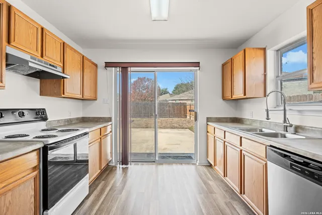 a kitchen with stainless steel appliances granite countertop a stove a sink and a refrigerator