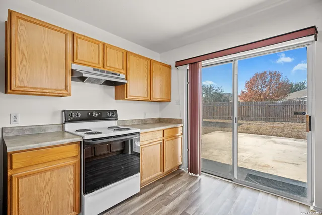 a kitchen with a stove top oven sink and glass door