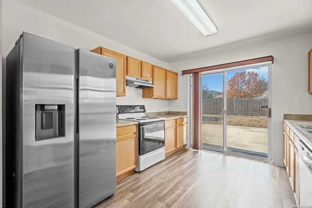 a kitchen with stainless steel appliances granite countertop a refrigerator and a stove top oven