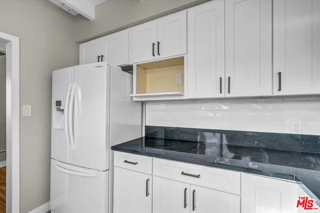 a kitchen with granite countertop white cabinets and a sink