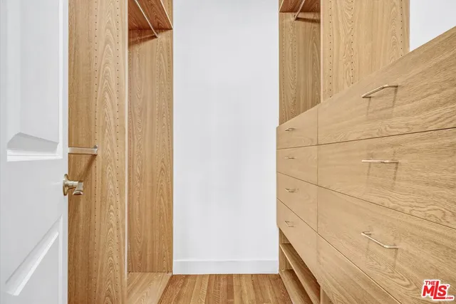 an empty room with wooden floor and a ceiling fan