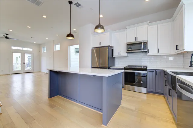 a kitchen with stainless steel appliances granite countertop a sink a stove top oven a counter space and cabinets