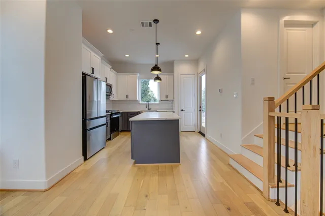 a view of kitchen with refrigerator and microwave