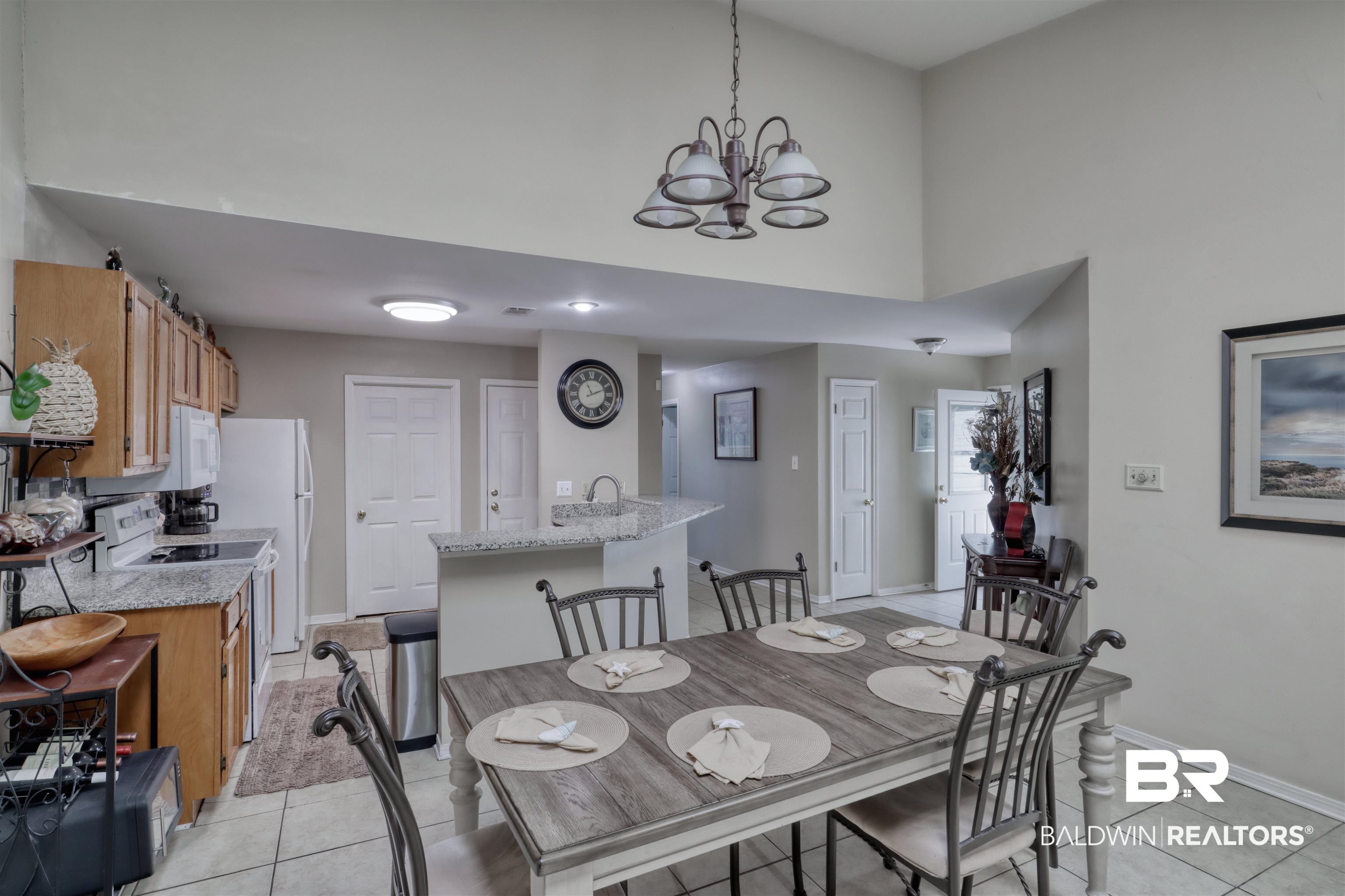 3200 Loop Road, Unit 61 Orange Beach, AL 36561 - Photo 6 of 32 Dining space with light tile patterned floors, a towering ceiling, and a chandelier