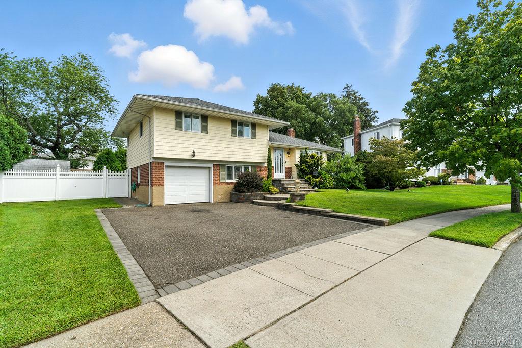21 Macarthur Avenue Plainview, NY 11803 - Photo 1 of 26 a front view of a house with a yard and garage