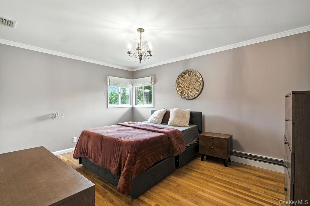 21 Macarthur Avenue Plainview, NY 11803 - Photo 14 of 26 a bedroom with a bed and a table