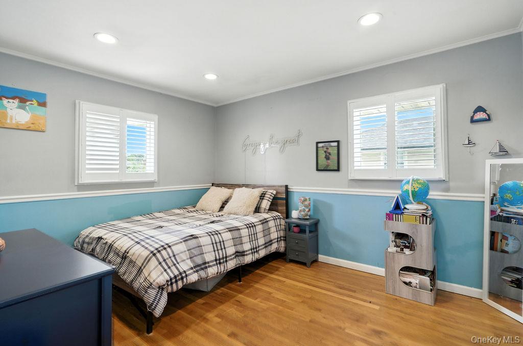 21 Macarthur Avenue Plainview, NY 11803 - Photo 15 of 26 a bedroom that has a bed and a table in it