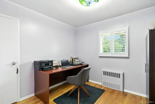 a view of a workspace with furniture and a window