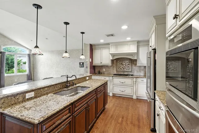 a kitchen with granite countertop kitchen island sink stove and refrigerator