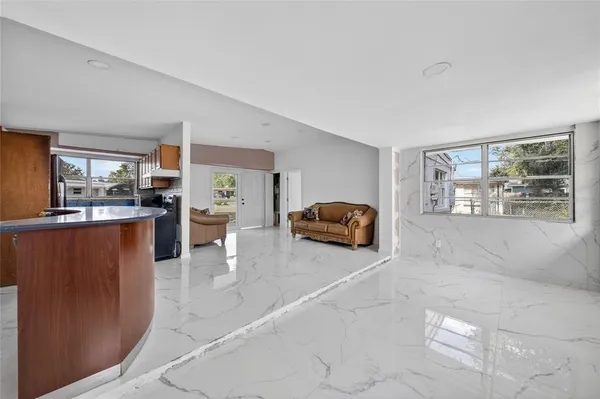 a living room with stainless steel appliances kitchen island granite countertop furniture and a view of kitchen