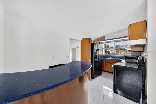 a kitchen with stainless steel appliances granite countertop a sink and a refrigerator