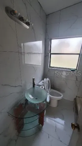 a bathroom with a toilet sink and mirror