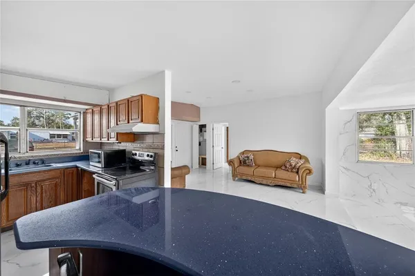 a kitchen with stainless steel appliances granite countertop a sink a stove counter space and cabinets