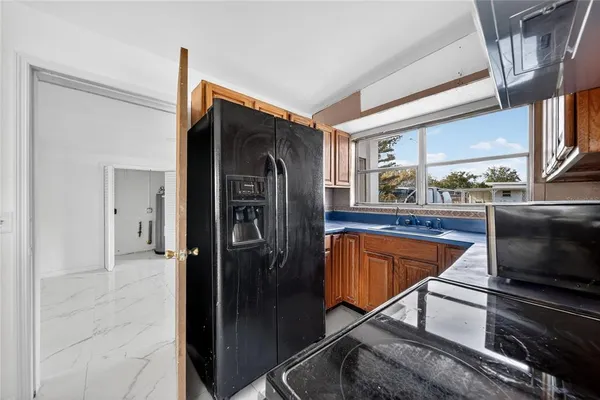 a kitchen with stainless steel appliances kitchen island granite countertop a refrigerator and a stove