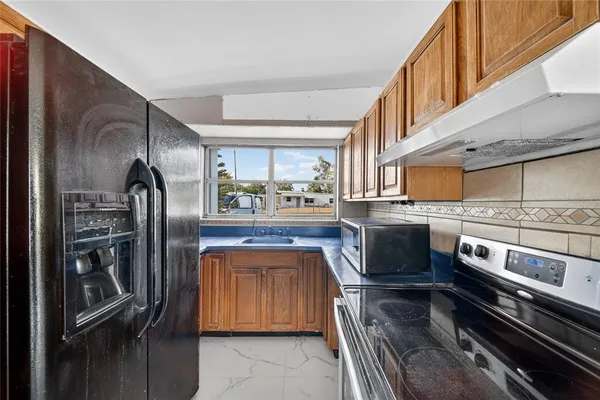 a kitchen with stainless steel appliances granite countertop a refrigerator and a stove