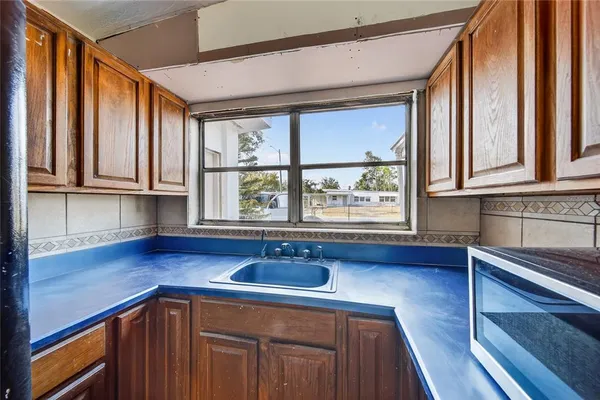 a kitchen with stainless steel appliances granite countertop wooden cabinets a sink and a large window