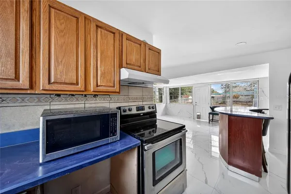 a kitchen with stainless steel appliances granite countertop a stove microwave and sink