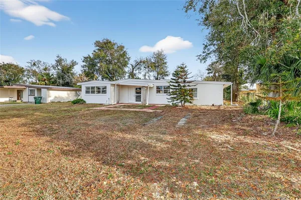a view of a house with backyard and sitting area