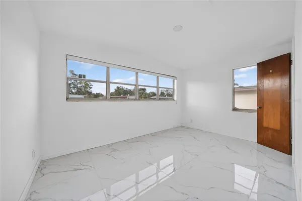 an empty room with windows and closet