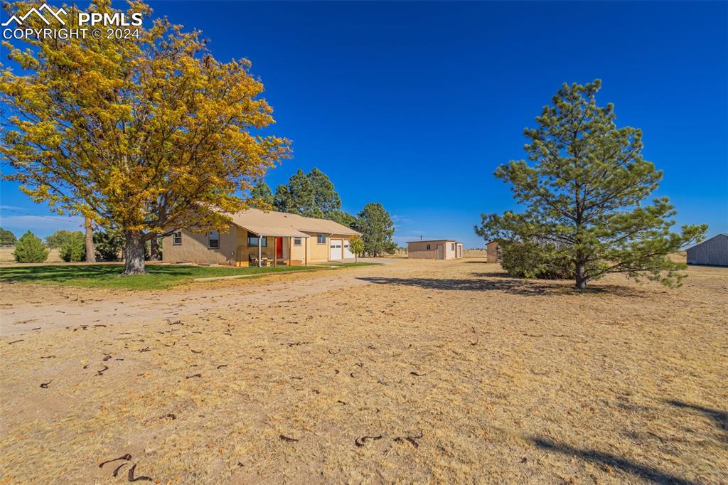 375 North Rush Road Rush, CO 80833 - Photo 4 of 32 a yellow house with trees in front of it