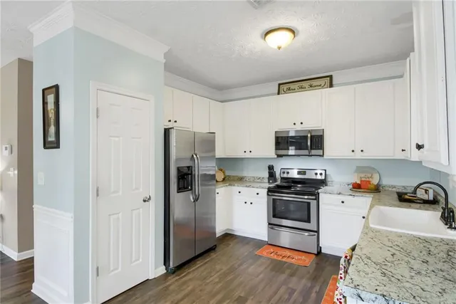 a kitchen with stainless steel appliances granite countertop a refrigerator stove and sink