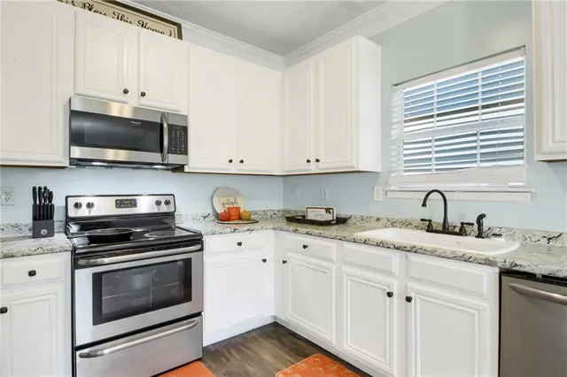 a kitchen with granite countertop cabinets stainless steel appliances and a sink