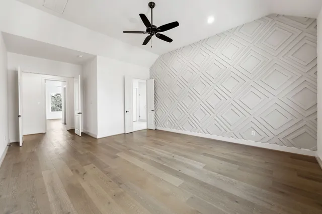 a view of a livingroom with a ceiling fan wooden floor and a ceiling fan