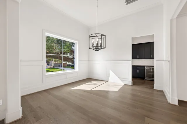 a view of empty room with wooden floor and ceiling fan