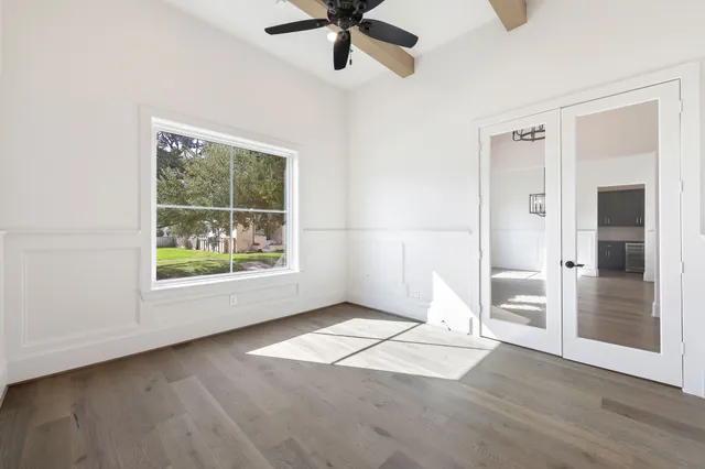 an empty room with fan and windows