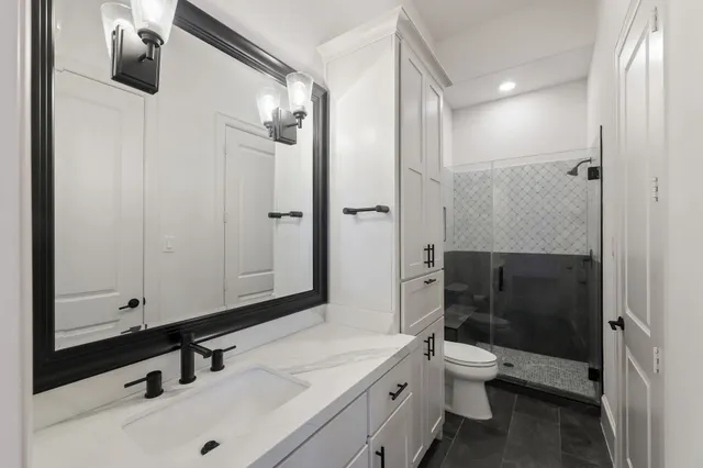 a bathroom with a sink a toilet and shower