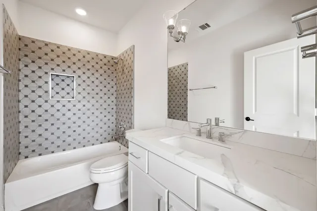 a bathroom with a sink toilet vanity and shower