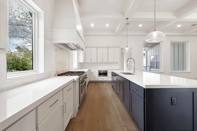 an open kitchen with a sink a counter top space stainless steel appliances and a large window