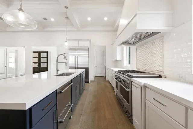 a kitchen with stainless steel appliances granite countertop a lot of counter space and wooden floors