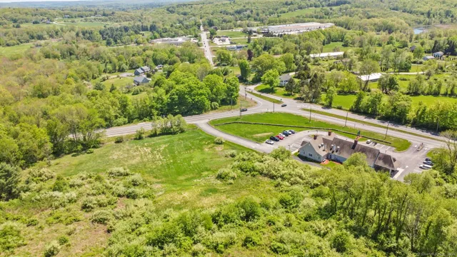 an aerial view of residential houses with outdoor space and trees