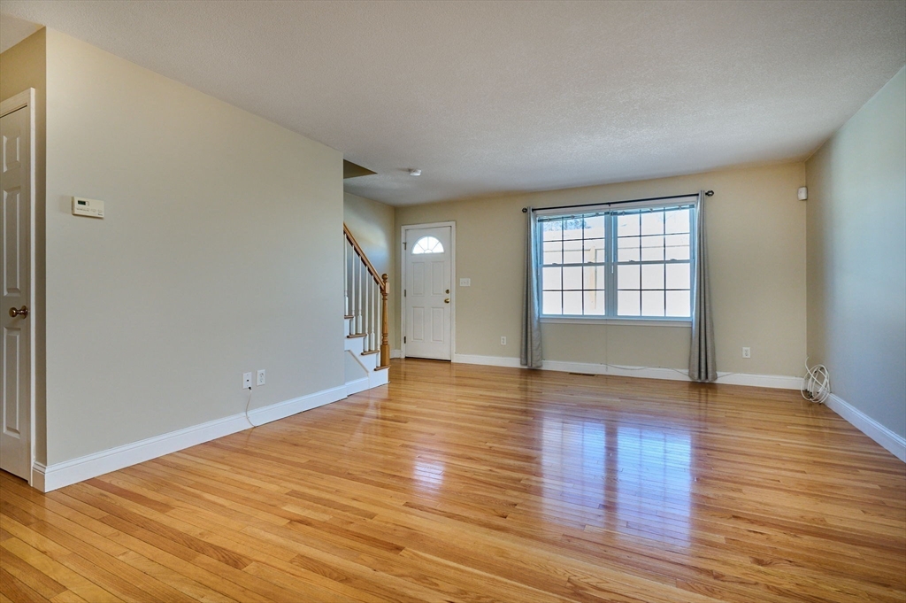 8 Hockanum Road, Unit 10 Northampton, MA 01060 - Photo 7 of 34 a view of an empty room with wooden floor and a window