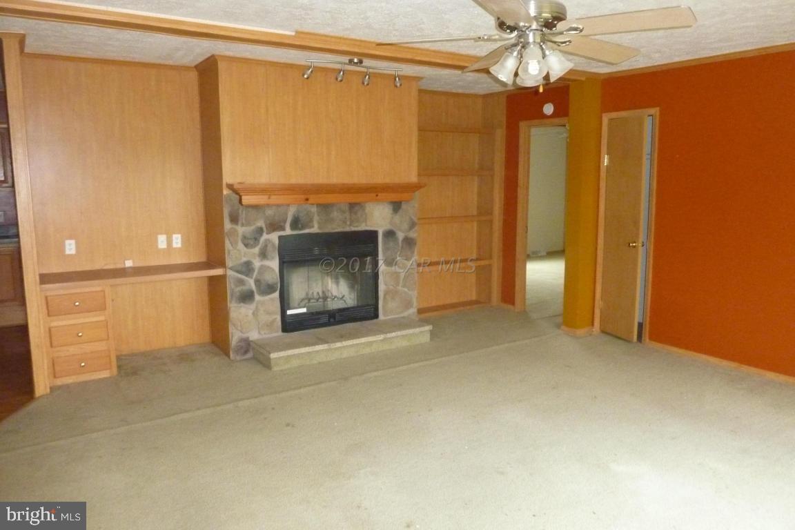6380 Powellville Road Willards, MD 21874 - Photo 3 of 10 a view of an empty room with a fireplace and a window