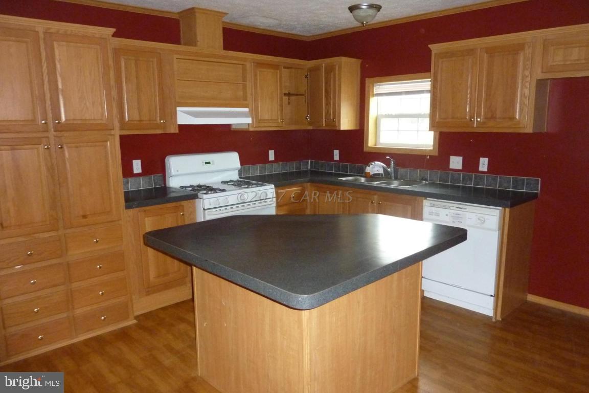 6380 Powellville Road Willards, MD 21874 - Photo 7 of 10 a kitchen with stainless steel appliances granite countertop a sink a stove window and cabinets